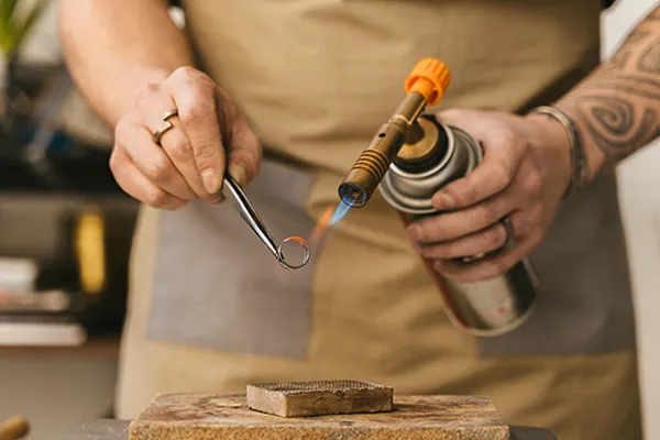 Jeweler using magnifying loupe for diamond appraisal, accurate jewelry valuation for insurance and estates.