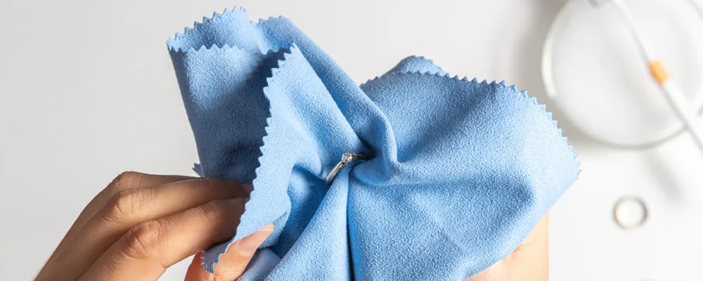 Close-up of a hand showing jewelry cleaning and inspection