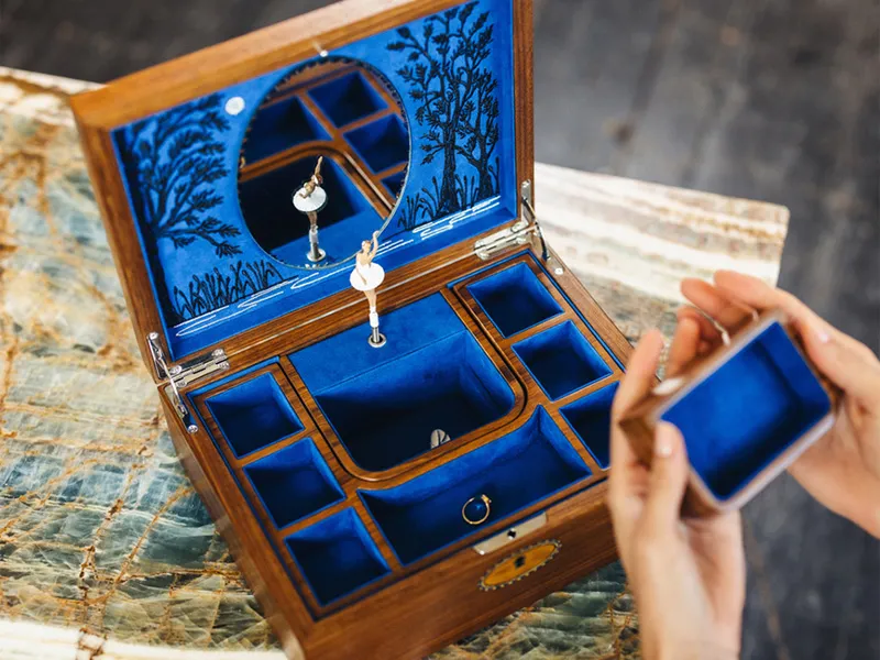  Hand organizing jewelry in brown WOLF Ida Trunk Jewelry Box