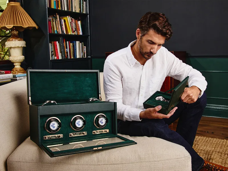 Man holding WOLF watch winder from green leather case