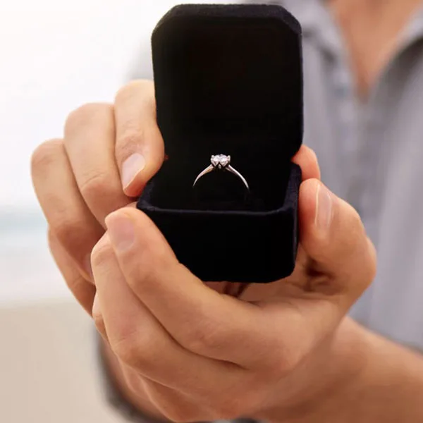 Man proposing with diamond engagement ring in black box