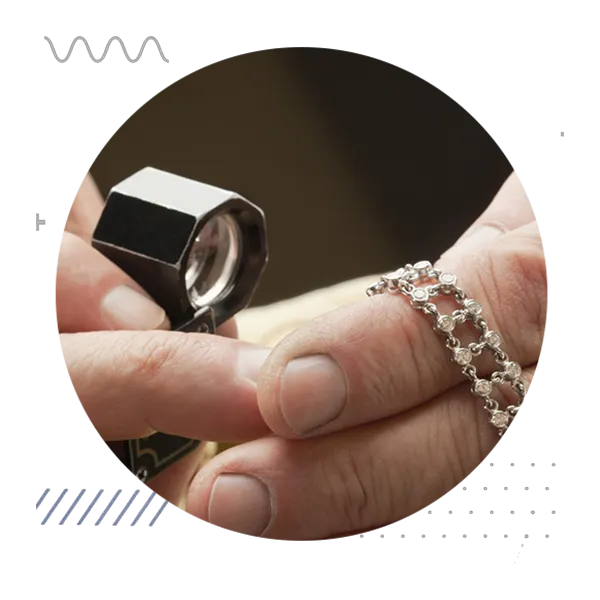 Jeweler examining silver bracelet with loupe during appraisal